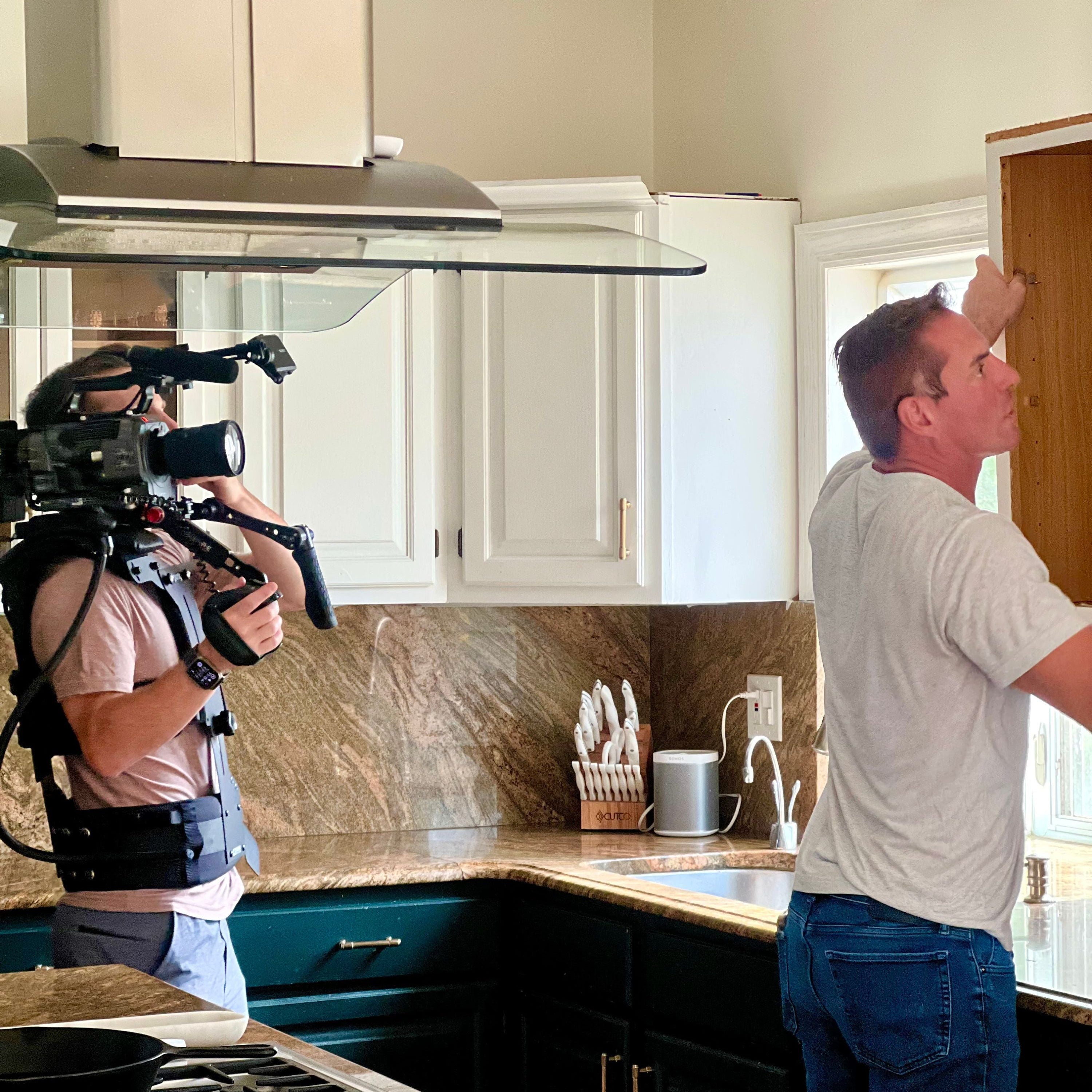 Joe taking down a cabinet while filmmaker is filming him 